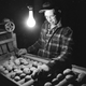 circa 1955: An American farmer sorts the good from the bad on the ‘spud line’ under the meagre light and warmth from a single bulb, in the White Mountains of New Hampshire.
